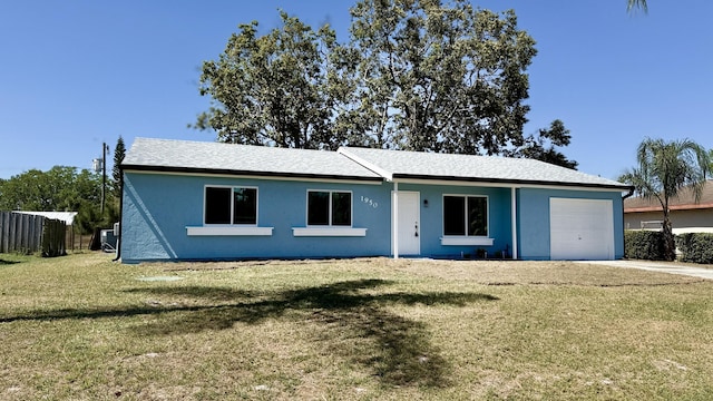 ranch-style home featuring concrete driveway, an attached garage, fence, a front yard, and stucco siding