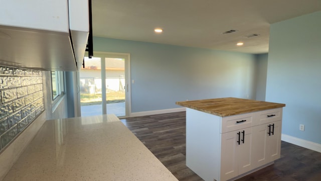 kitchen featuring dark wood-style flooring, white cabinets, visible vents, and baseboards