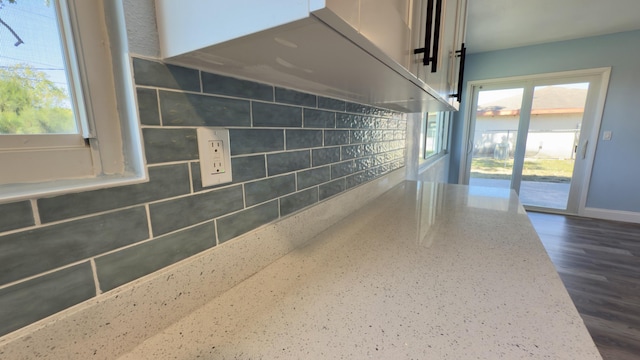 interior space with light stone counters, dark wood-type flooring, and baseboards