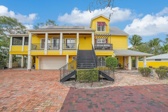 view of building exterior with stairway, decorative driveway, and a garage