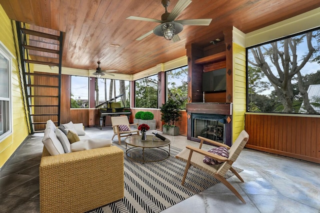 sunroom / solarium with wooden ceiling, an outdoor fireplace, and a ceiling fan