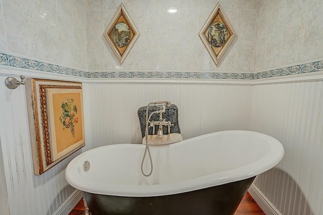 full bathroom featuring a soaking tub and baseboards