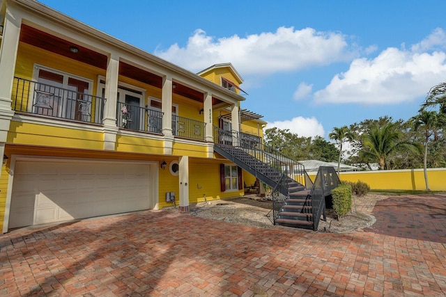 view of front of house featuring stairway, decorative driveway, and a garage