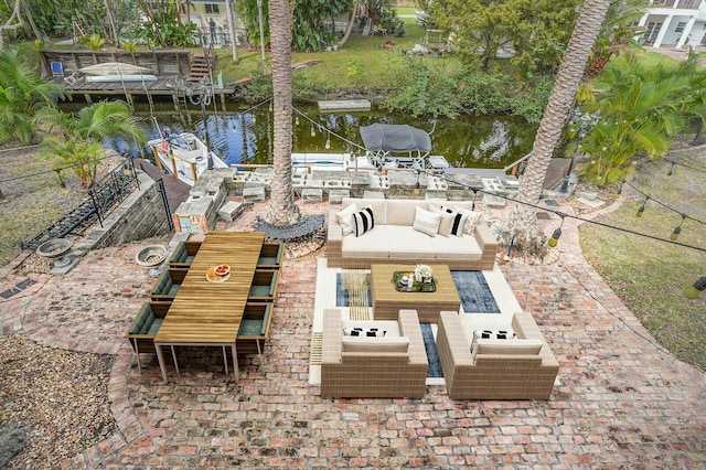 view of patio / terrace with outdoor lounge area, a boat dock, and a water view