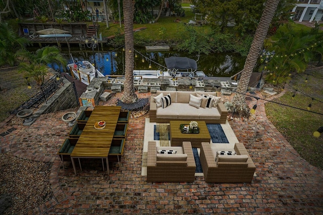 view of patio featuring an outdoor living space, a water view, and a boat dock