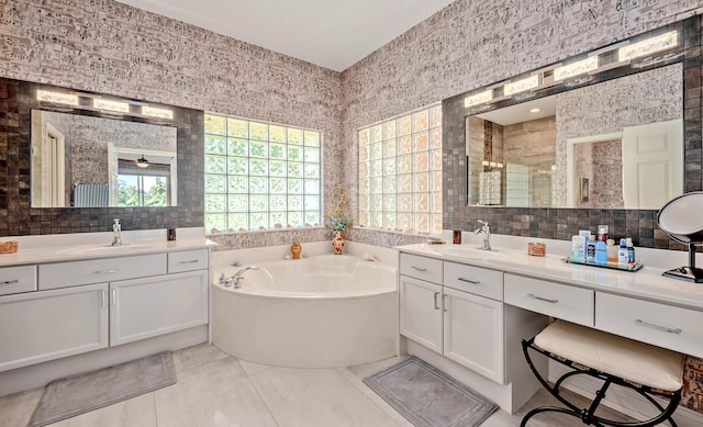 full bathroom featuring a stall shower, tile walls, a garden tub, and a sink