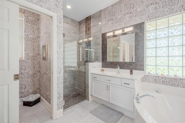 bathroom featuring a bath, tile patterned flooring, a stall shower, and vanity