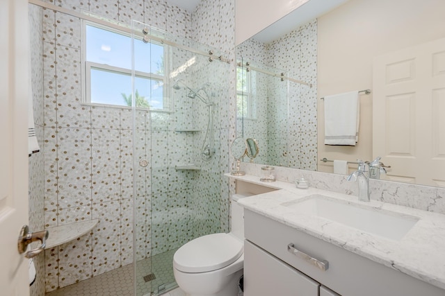 full bathroom with toilet, a stall shower, and vanity