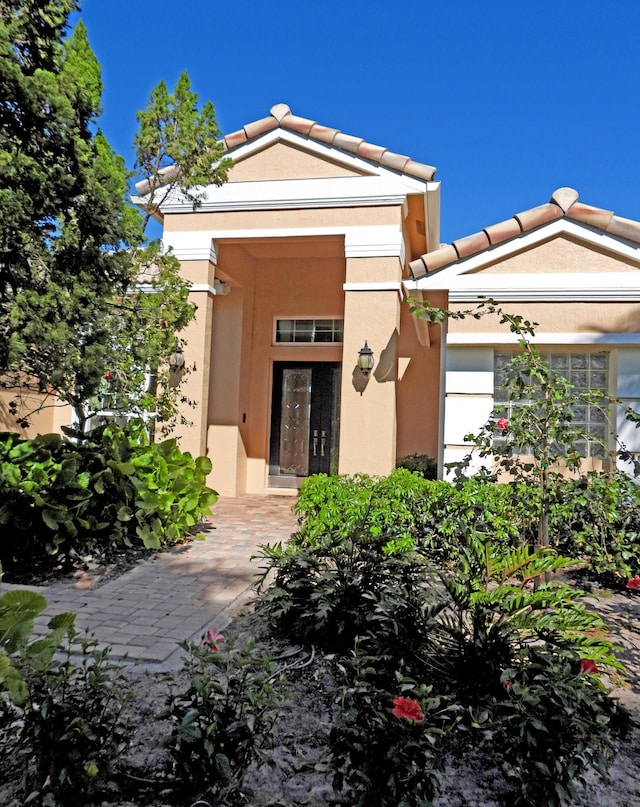 view of front of property featuring stucco siding and a tiled roof