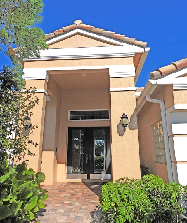 entrance to property with stucco siding and french doors