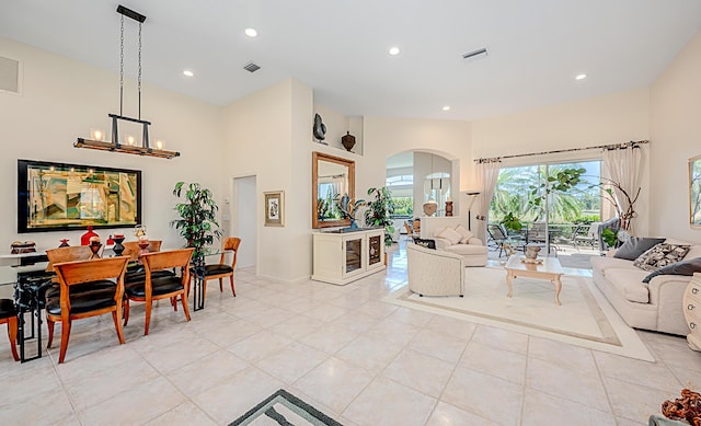 living area featuring visible vents, a notable chandelier, recessed lighting, a high ceiling, and light tile patterned floors