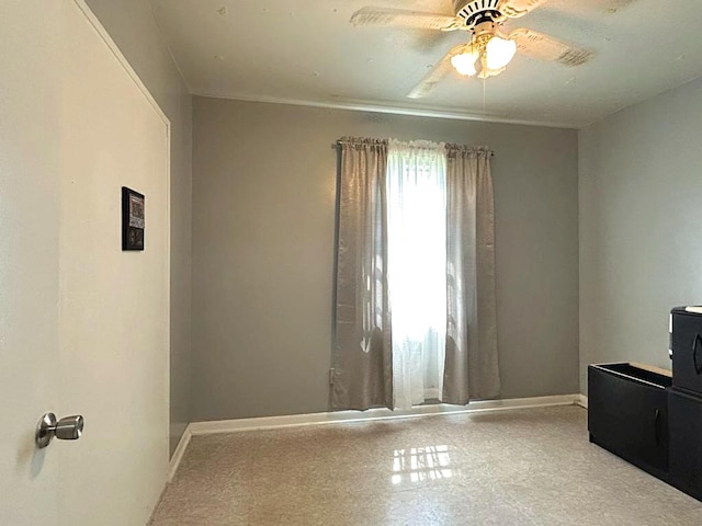 empty room featuring baseboards and a ceiling fan