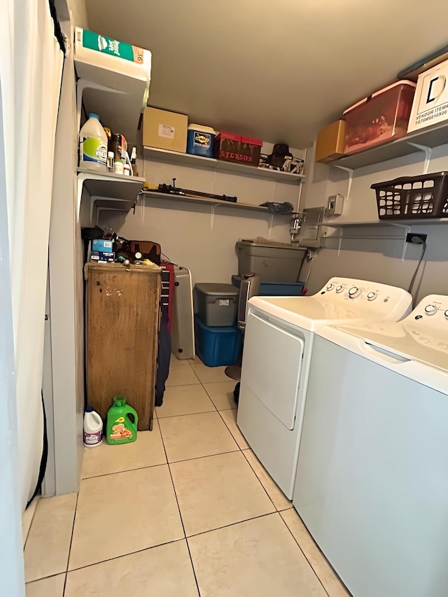 clothes washing area featuring light tile patterned floors, laundry area, and washing machine and clothes dryer