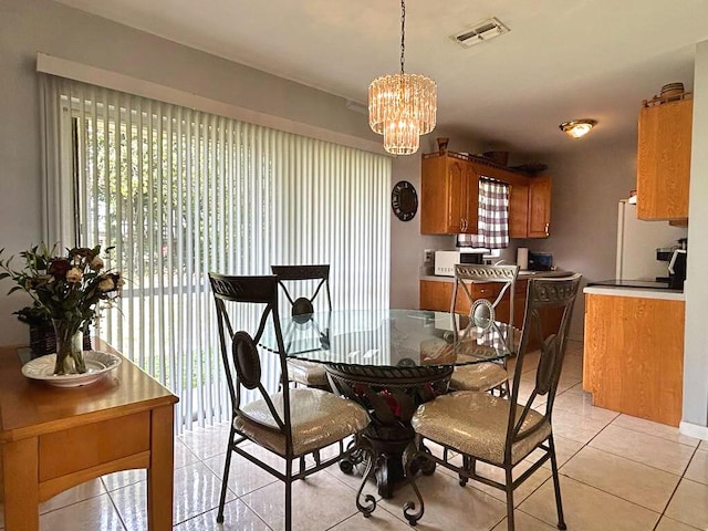 dining room with light tile patterned floors, visible vents, and a notable chandelier