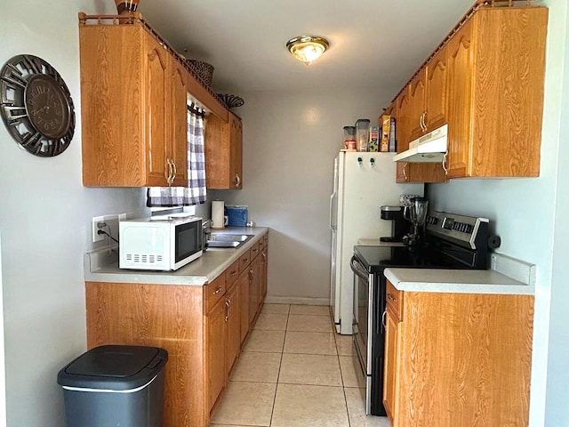 kitchen featuring white microwave, light countertops, stainless steel range with electric cooktop, under cabinet range hood, and a sink