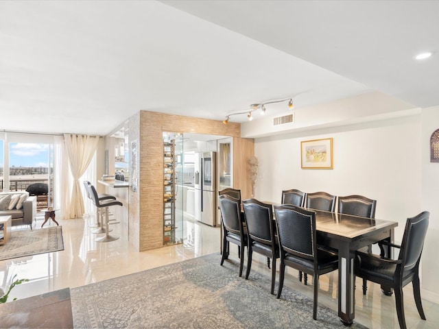 dining space with rail lighting, baseboards, and visible vents