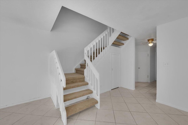 stairs featuring tile patterned flooring, baseboards, and a ceiling fan