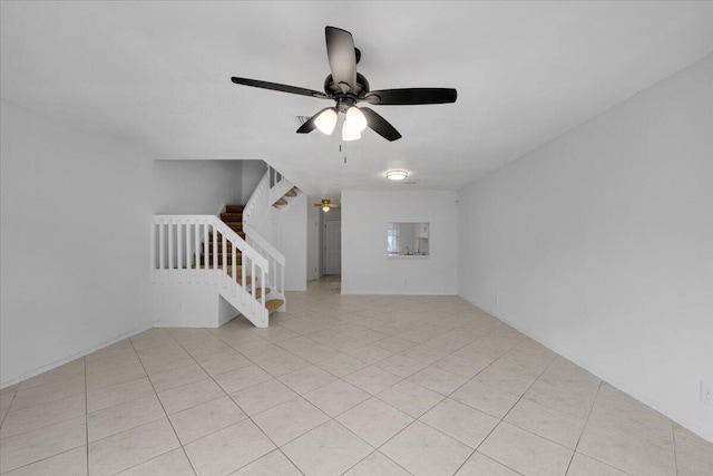 unfurnished living room featuring stairway and a ceiling fan