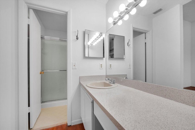 full bathroom featuring visible vents, a stall shower, and vanity