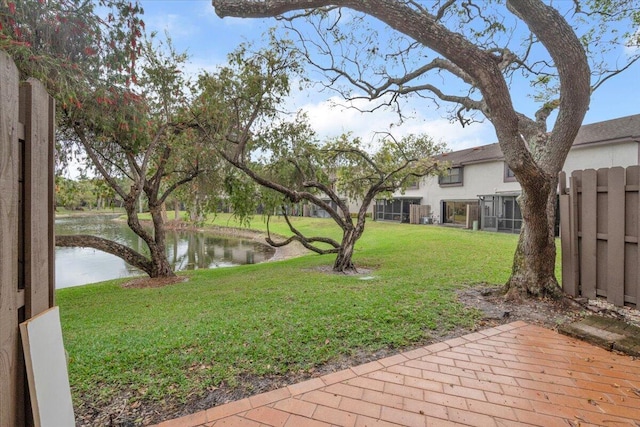 view of yard featuring fence and a water view