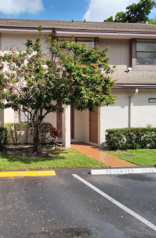 view of front of property featuring stucco siding and uncovered parking