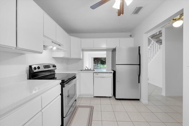 kitchen with a ceiling fan, under cabinet range hood, a sink, stainless steel appliances, and light countertops