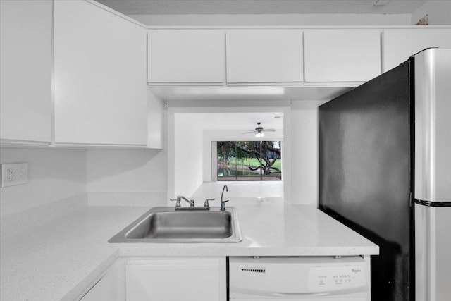 kitchen featuring a sink, freestanding refrigerator, white cabinets, light countertops, and dishwasher