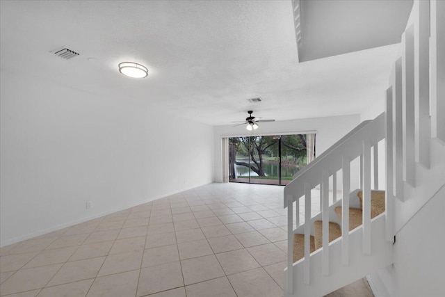 interior space featuring visible vents, a textured ceiling, and tile patterned flooring