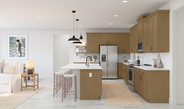 kitchen with an island with sink, appliances with stainless steel finishes, light countertops, and decorative light fixtures