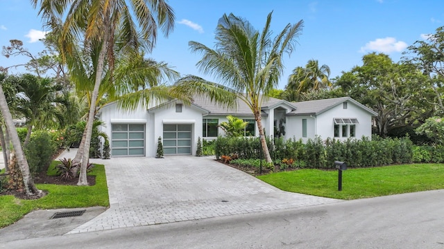 4545 S Lake Dr, Boynton Beach, FL 33436 - view of front of home featuring a garage, decorative driveway, a front yard, and stucco siding