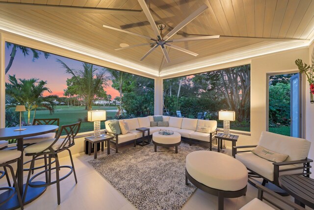 view of patio featuring a ceiling fan, outdoor dining space, and an outdoor living space with a fire pit