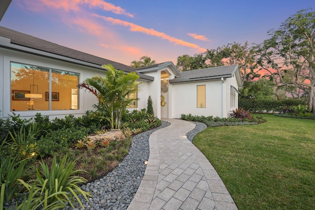 view of front of house featuring a yard and stucco siding