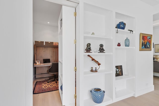 corridor featuring baseboards and wood finished floors