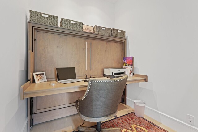 office space featuring built in desk and baseboards