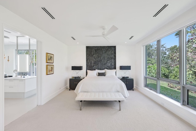 bedroom with light carpet, ensuite bath, visible vents, and a ceiling fan