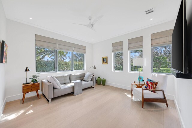 living area featuring light wood-style floors, plenty of natural light, and visible vents