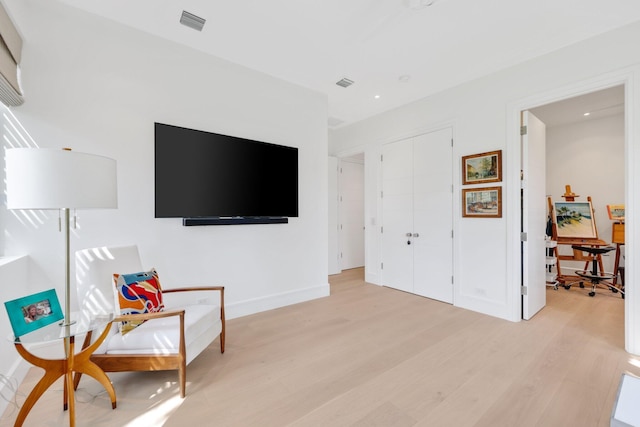 sitting room featuring light wood-style floors, recessed lighting, visible vents, and baseboards