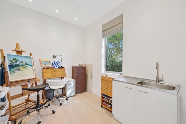 office space featuring light wood-type flooring, baseboards, a sink, and recessed lighting