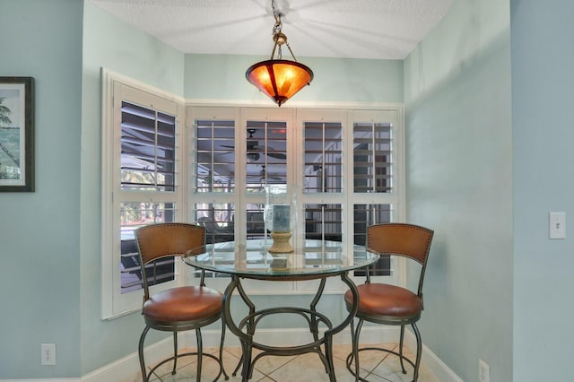 dining area with baseboards and a textured ceiling