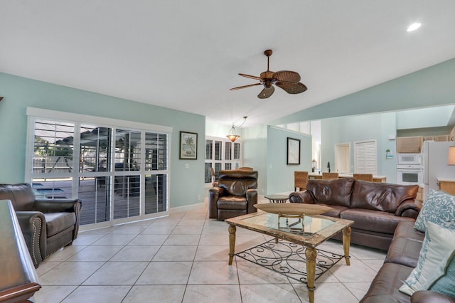 living area featuring light tile patterned floors, vaulted ceiling, and a ceiling fan