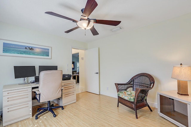 office space featuring light wood-style flooring, visible vents, and a ceiling fan