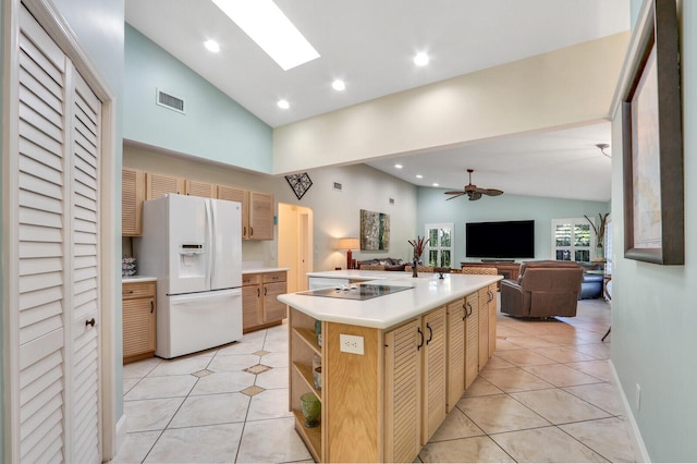 kitchen featuring a skylight, visible vents, a ceiling fan, black electric cooktop, and white fridge with ice dispenser