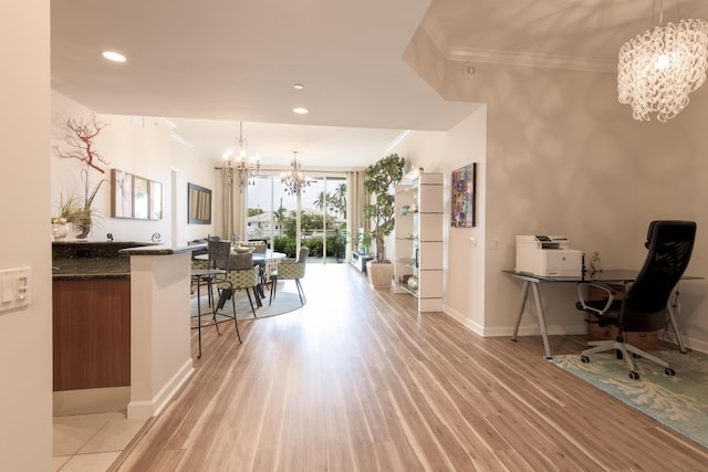 dining space with crown molding, light wood-style floors, a notable chandelier, and baseboards