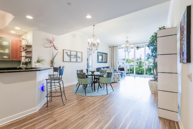 dining area with a chandelier, light wood-type flooring, baseboards, and recessed lighting