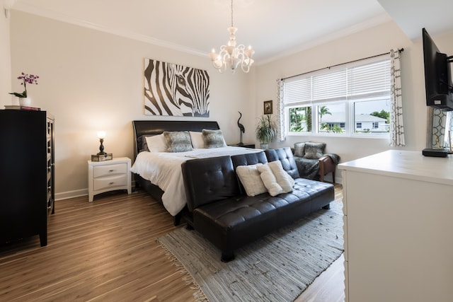 bedroom featuring a notable chandelier, baseboards, wood finished floors, and crown molding