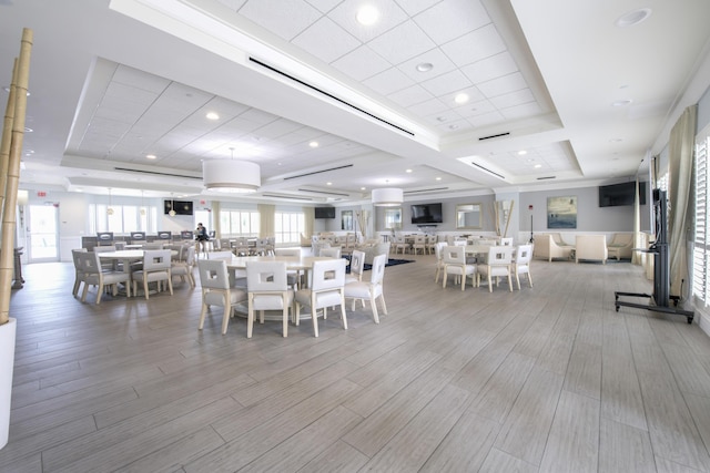 dining room featuring wood finished floors, a raised ceiling, and recessed lighting