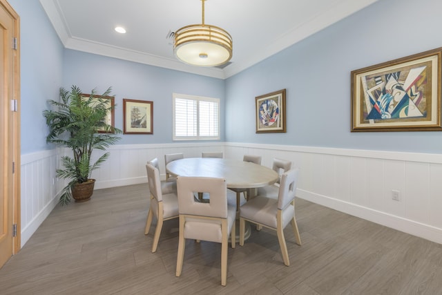 dining area with ornamental molding, recessed lighting, wainscoting, and light wood finished floors