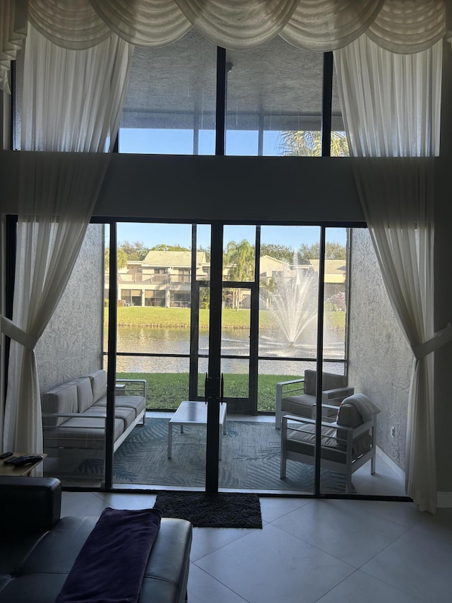 doorway with a water view, a high ceiling, and a wealth of natural light