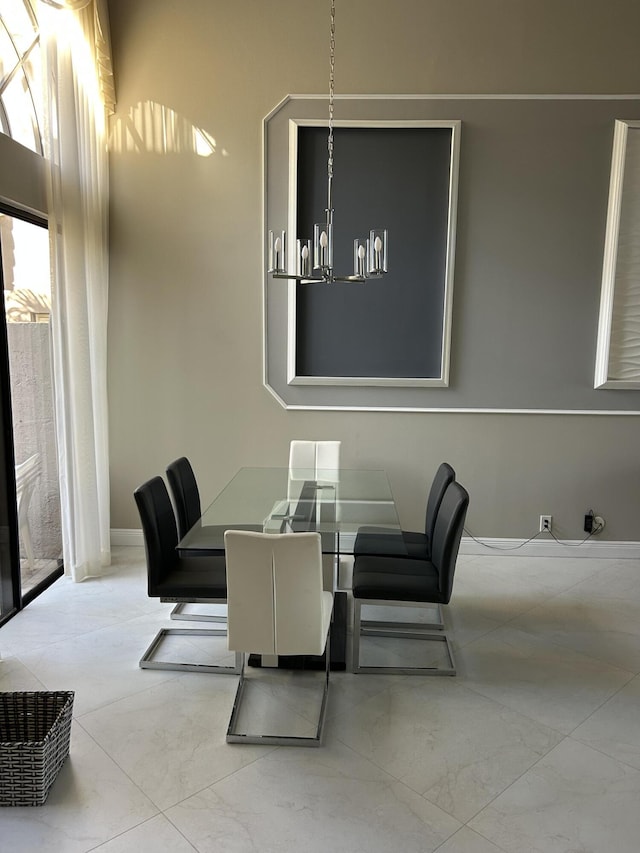 dining space featuring a chandelier and marble finish floor