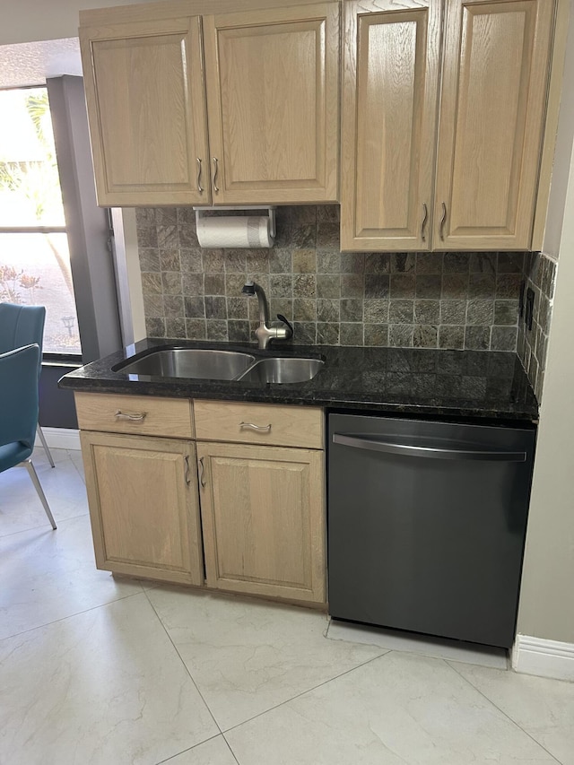 kitchen featuring dishwashing machine, light brown cabinetry, and a sink